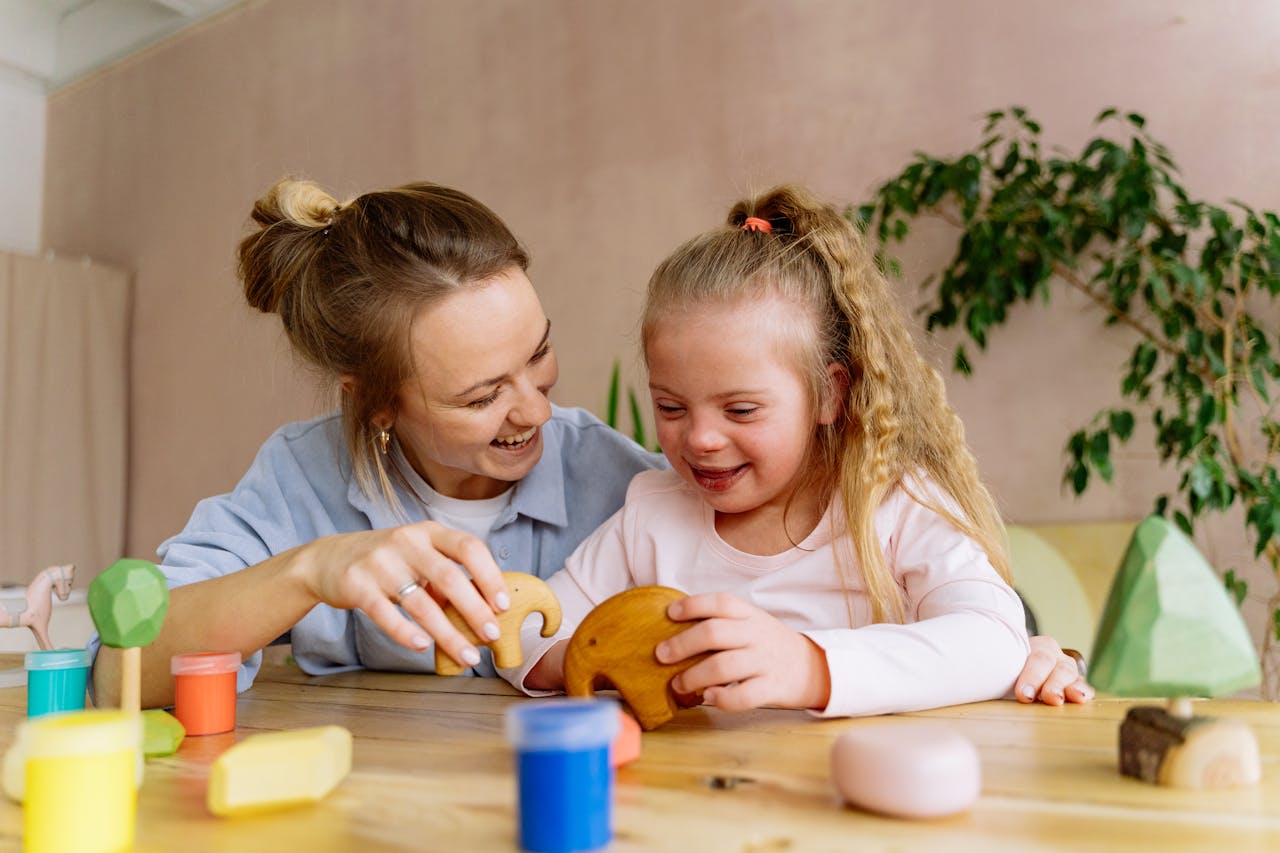 A joyful mother and daughter bonding while playing with toys indoors.